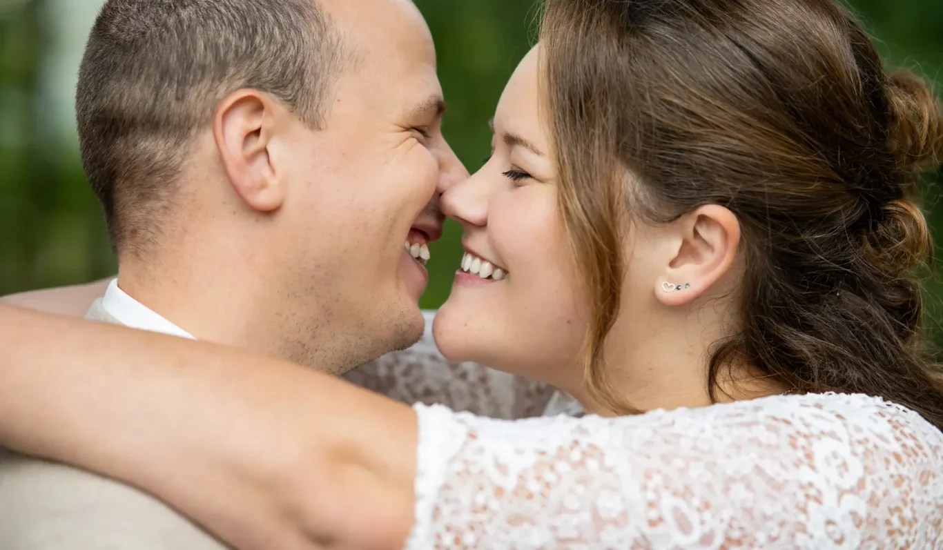 Hochzeit in Dringenberg Ein Paar lächelt sich an und umarmt sich innig in einer natürlichen Umgebung.