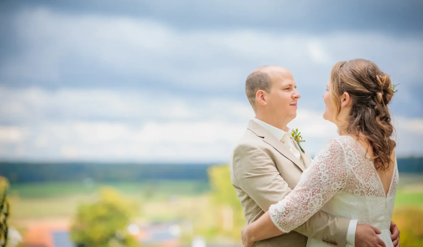 Hochzeit in Dringenberg Ein Paar lächelt sich an und umarmt sich innig in einer natürlichen Umgebung.